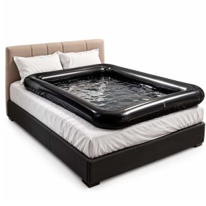 Liquid Blocker Play Mat saltea neagra cu lichid asezata pe pat